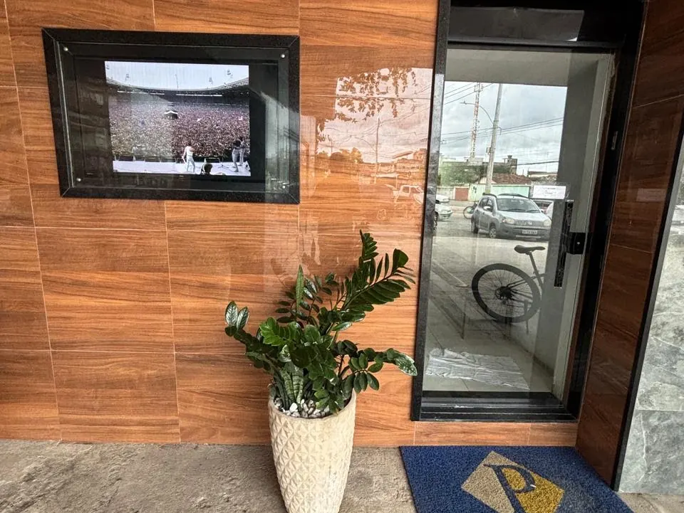 Porta de vidro do escritório com tapete azul e dourado com a letra P do logo